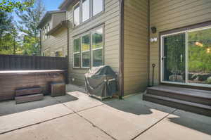 View of patio featuring grilling area and a hot tub