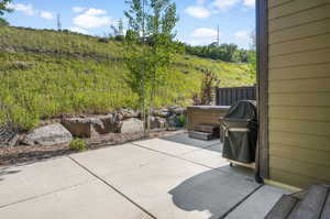 View of patio / terrace with area for grilling and a jacuzzi