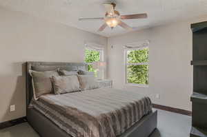 Bedroom featuring a textured ceiling, carpet floors, and ceiling fan