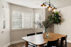 Dining room featuring dark wood-type flooring and a textured ceiling