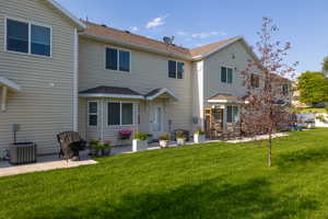 Rear view of house featuring cooling unit, a patio area, and a yard