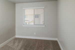 Carpeted spare room featuring a wealth of natural light