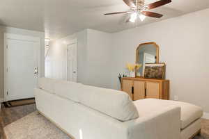 Living room featuring dark wood-type flooring and ceiling fan