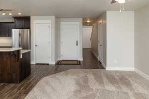 Kitchen featuring ceiling fan, dark wood-type flooring, stainless steel refrigerator, and rail lighting