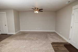 Carpeted spare room featuring ceiling fan