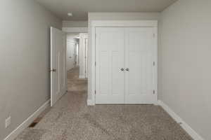 Unfurnished bedroom with a closet and carpet floors