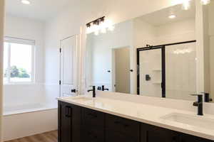 Bathroom featuring independent shower and bath, hardwood / wood-style flooring, and vanity