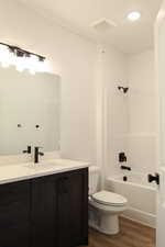 Full bathroom featuring shower / bathtub combination, hardwood / wood-style floors, vanity, and toilet