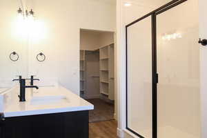 Bathroom with vanity, walk in shower, and hardwood / wood-style floors