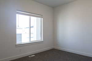 Unfurnished room with dark carpet