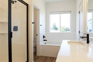 Full bathroom featuring wood-type flooring, vanity, toilet, and plus walk in shower