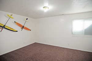 Carpeted empty room with a textured ceiling