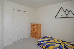 Carpeted bedroom featuring a closet