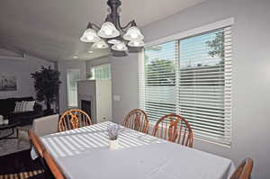 Dining room with a notable chandelier and vaulted ceiling