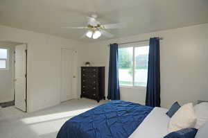 Carpeted bedroom featuring ceiling fan