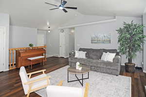 Living room with lofted ceiling, ceiling fan, and dark hardwood / wood-style floors