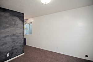 Spare room with a textured ceiling and carpet