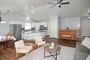 Living room with high vaulted ceiling, ceiling fan, dark hardwood / wood-style flooring, and sink