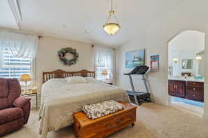 Tiled bedroom with lofted ceiling, multiple windows, and sink