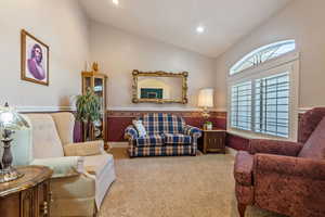 Carpeted living room with vaulted ceiling