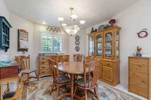 Tiled dining area featuring a notable chandelier