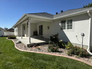 Rear view of house featuring a lawn and a deck