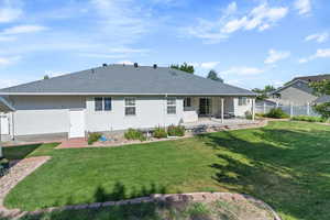 Rear view of property with a patio and a yard