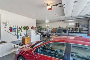 Garage featuring a garage door opener and white fridge