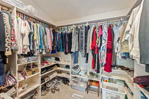 Spacious closet with carpet flooring and lofted ceiling