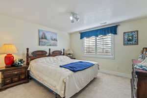 Bedroom featuring light carpet and a textured ceiling