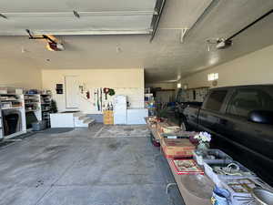 Garage with a garage door opener and white refrigerator