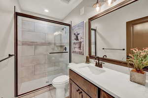 Bathroom with walk in shower, tile patterned floors, toilet, and vanity