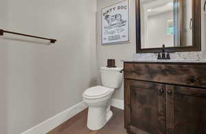 Bathroom with toilet, hardwood / wood-style floors, and vanity