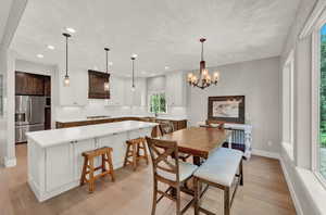 Dining space featuring light hardwood / wood-style flooring, sink, and a chandelier