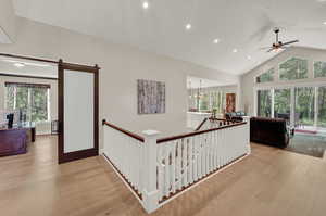 Hallway featuring a healthy amount of sunlight, light hardwood / wood-style flooring, and a barn door