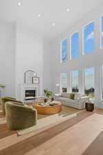 Living room with a fireplace & high ceiling