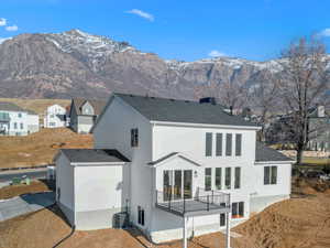 Back of house with a mountain view and a balcony