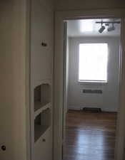 Hallway with radiator, rail lighting, and dark wood-type flooring