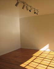 Unfurnished room featuring hardwood / wood-style flooring and rail lighting