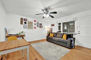 Living room with ceiling fan and hardwood / wood-style floors