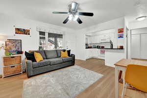 Living room featuring ceiling fan and light wood-type flooring