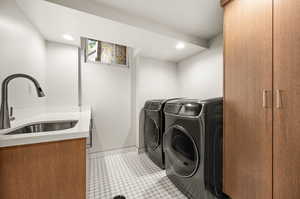 Clothes washing area featuring cabinets, separate washer and dryer, sink, and light tile patterned floors