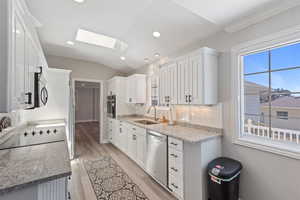 Kitchen with sink, white cabinets, plenty of natural light, and stainless steel appliances