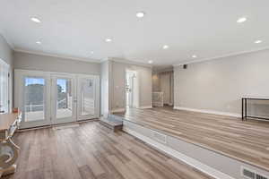 Foyer with light wood-type flooring and ornamental molding