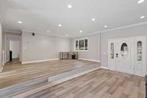 Foyer featuring ornamental molding and light hardwood / wood-style floors