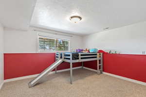 Bedroom featuring carpet floors and a textured ceiling