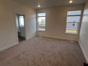 Empty room with a wealth of natural light and carpet