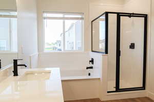 Bathroom featuring vanity, shower with separate bathtub, and hardwood / wood-style floors