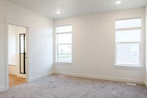 Carpeted empty room featuring a healthy amount of sunlight