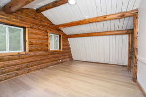 Interior space with vaulted ceiling with beams and light wood-type flooring